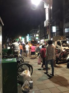 Large group of people carrying bags of trash.
