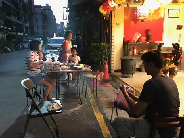 Family enjoying a street-side barbecue