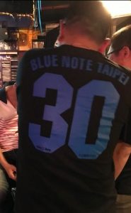 Man wearing a tee shirt that says "Blue Note Taipei 30"