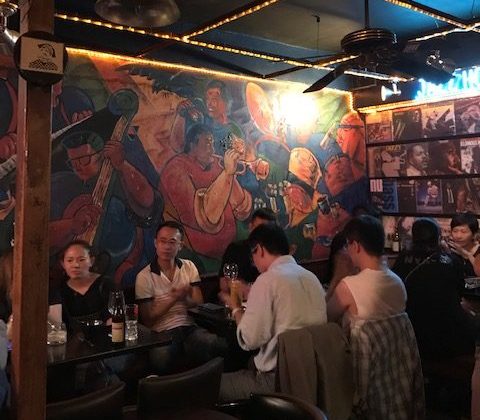 Patrons sitting in front of a jazz mural.