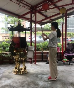 Woman offering incense in the temple.