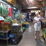 Shelley Rigger in a narrow lane filled with herb stalls.