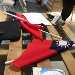 A table scattered with papers, ROC flags, and a microphone.