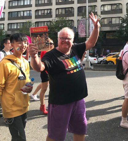 A western man holding a book.
