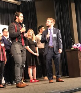 Two young men speaking on stage.