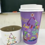 A paper coffee cup. There are a Christmas tree and the words "Las Vegas" and "Sharing" on the cup.