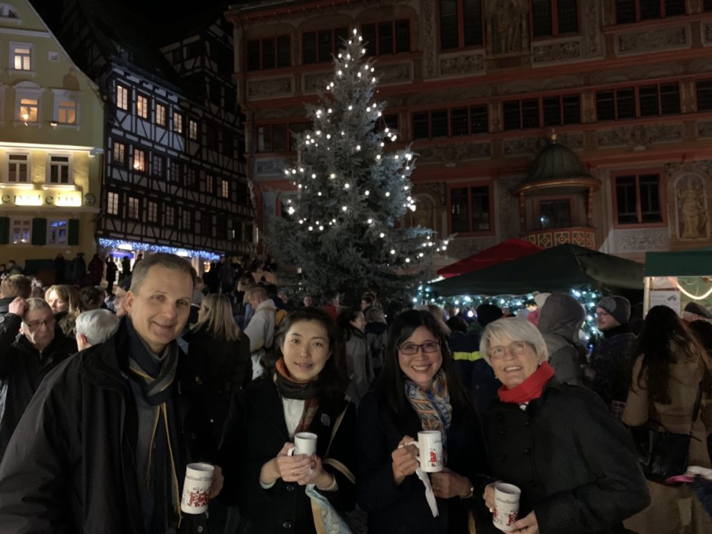 Four people in front of a Christmas tree.