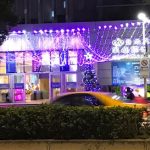 Building front with a canopy of purple lights.