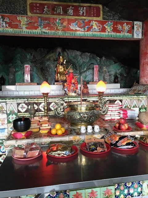 Temple altar with statues and offerings.