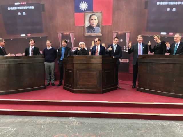 People standing in a mock-up of the Taiwanese legislative chamber.