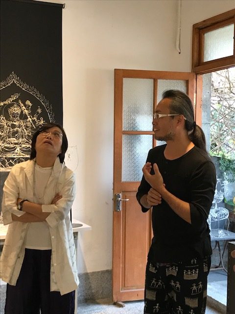 A man speaking to a woman, who is looking up.